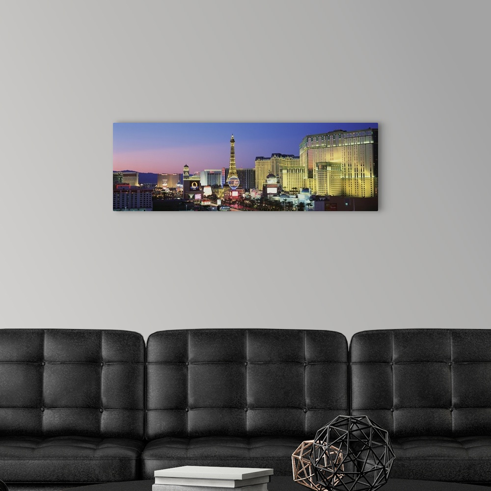 A modern room featuring Big panoramic canvas photo of the Las Vegas Strip illuminated at sunset.