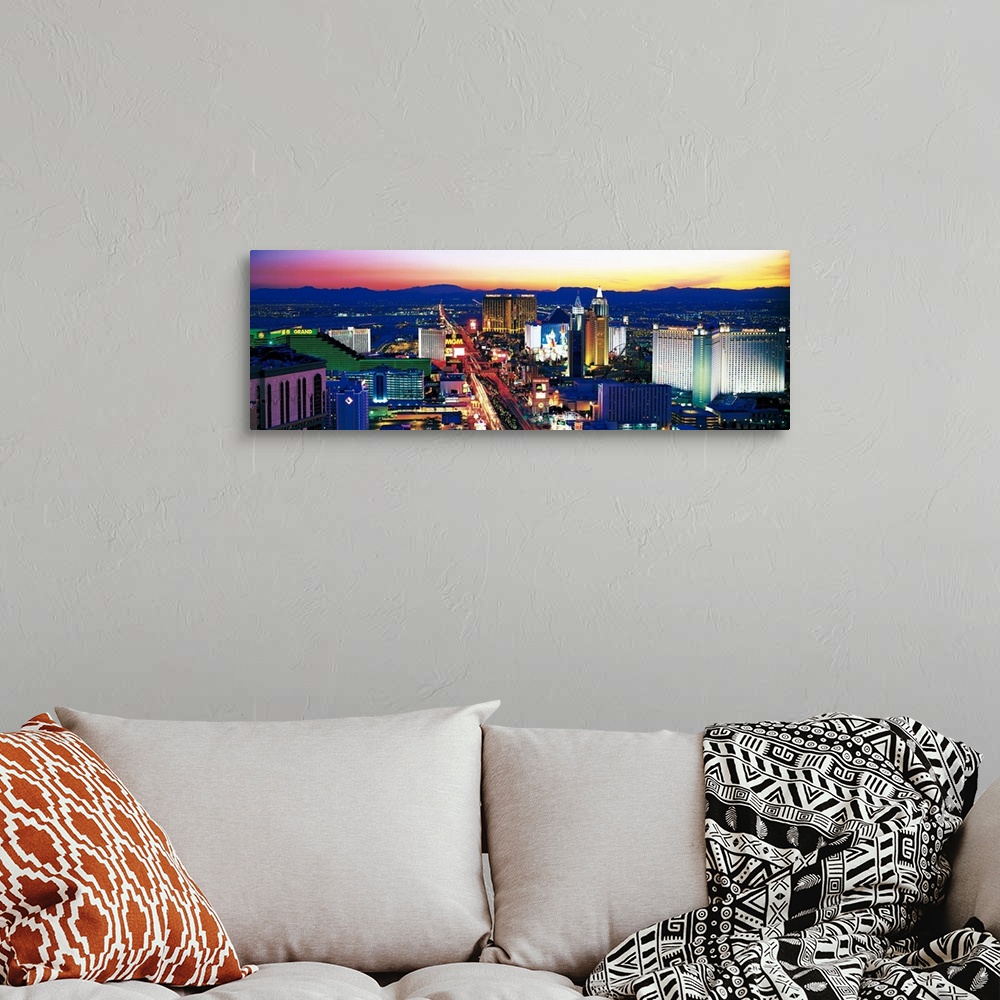 A bohemian room featuring Panoramic photograph of city at sunset with mountains in the distance.  The buildings are brightl...