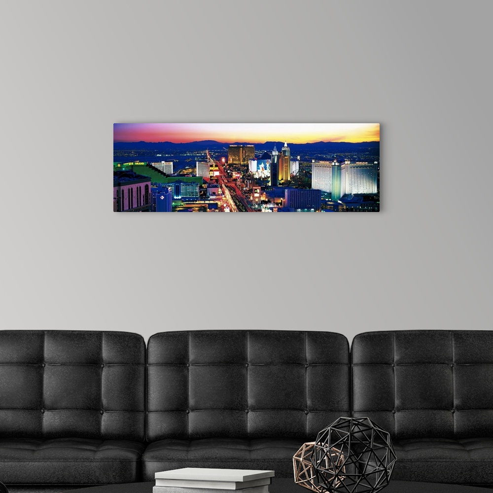 A modern room featuring Panoramic photograph of city at sunset with mountains in the distance.  The buildings are brightl...