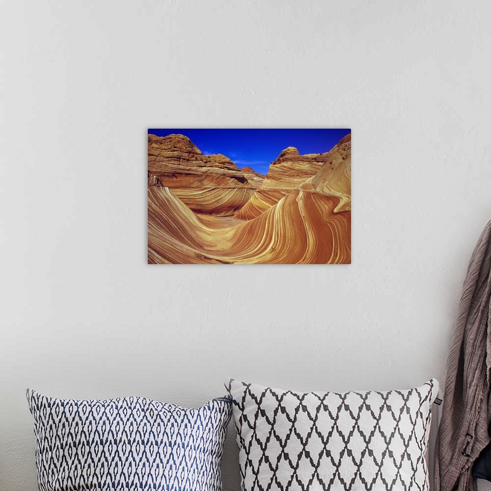 A bohemian room featuring Giant, horizontal photograph of the sandstone formation The Wave, against a deep blue sky in the ...