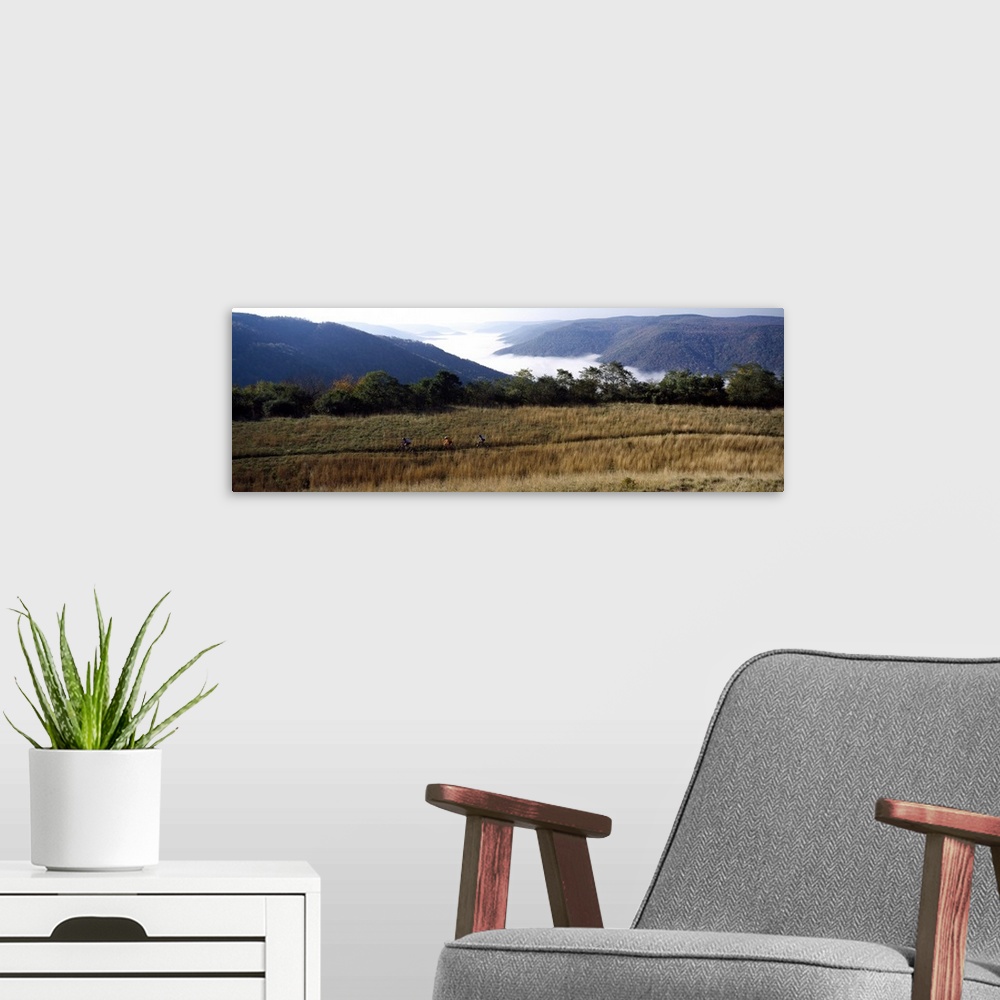 A modern room featuring Three people cycling with mountains in the background, West Virginia