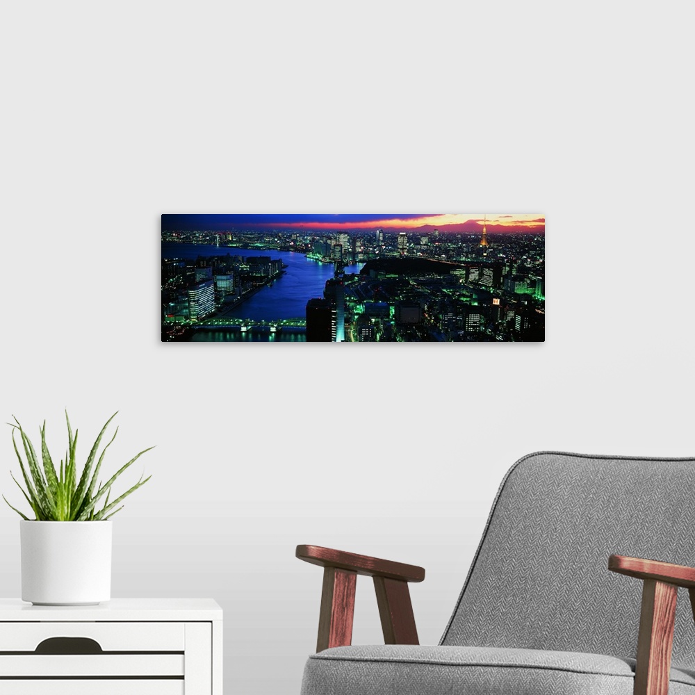 A modern room featuring Panoramic photo on canvas of a lit up downtown cityscape with water flowing through it.