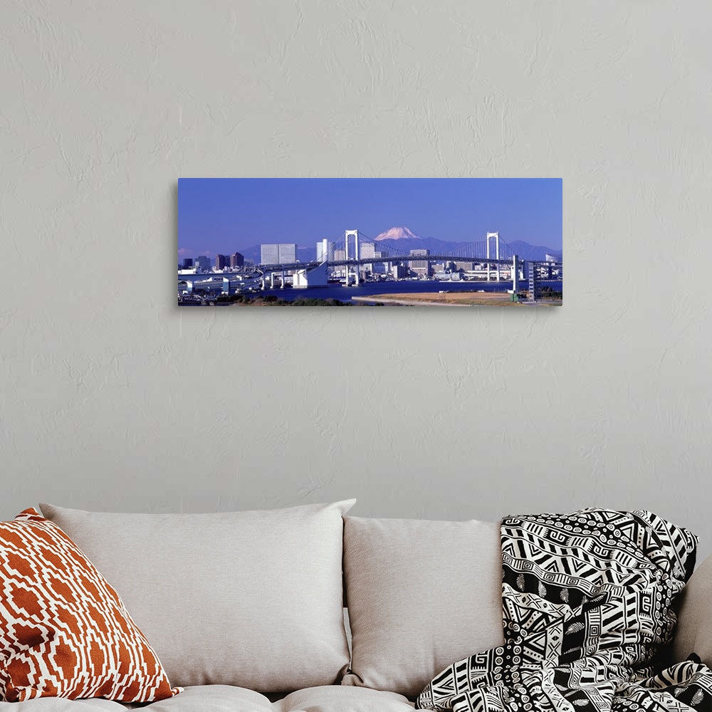 A bohemian room featuring Large panoramic piece of the Tokyo skyline with a bridge and buildings in full view and a mountai...