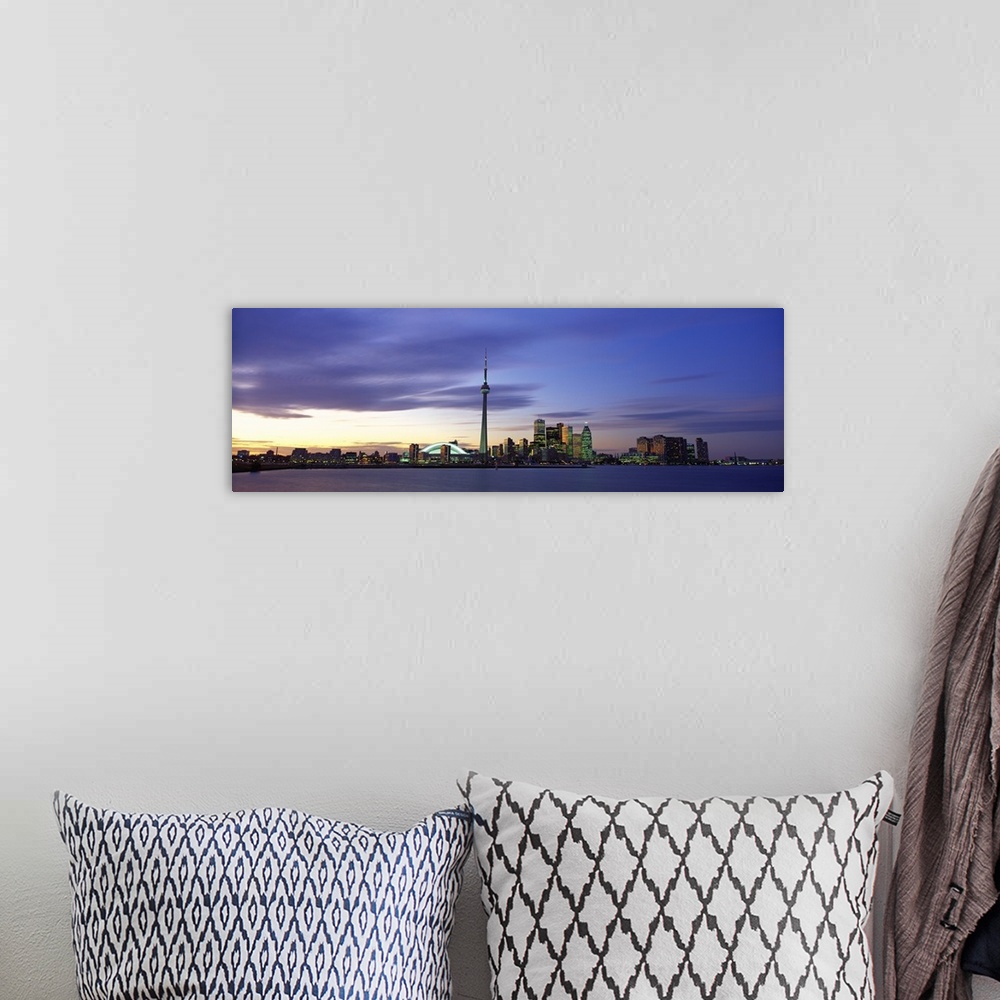 A bohemian room featuring This panoramic view is the city skyline at twilight taken from over the water.