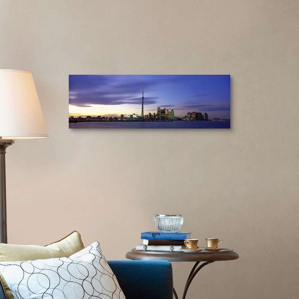 A traditional room featuring This panoramic view is the city skyline at twilight taken from over the water.