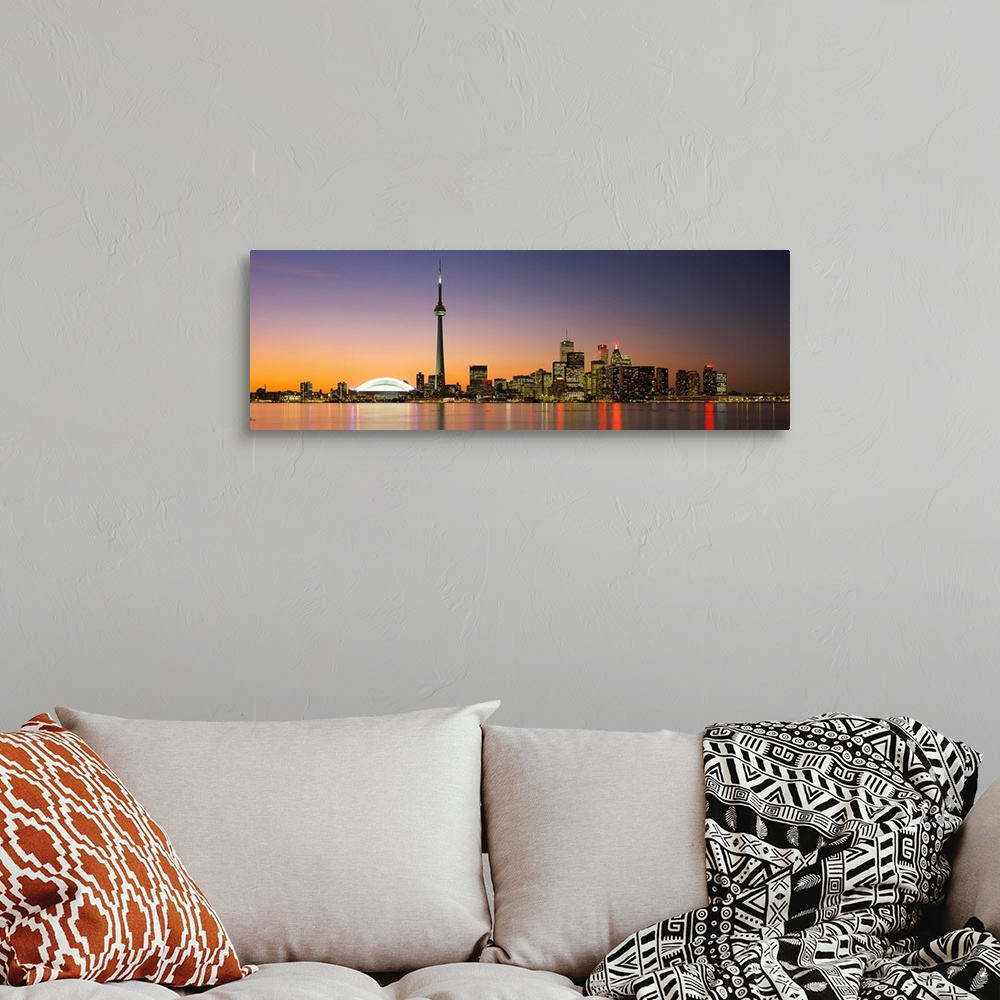 A bohemian room featuring Panoramic image of a cityscape at dusk with lights reflecting off of the water.