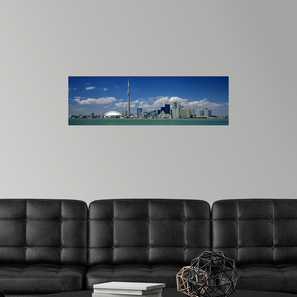 A modern room featuring Wide angle photograph on a large canvas of the Ontario skyline, including the CN Tower, in front ...