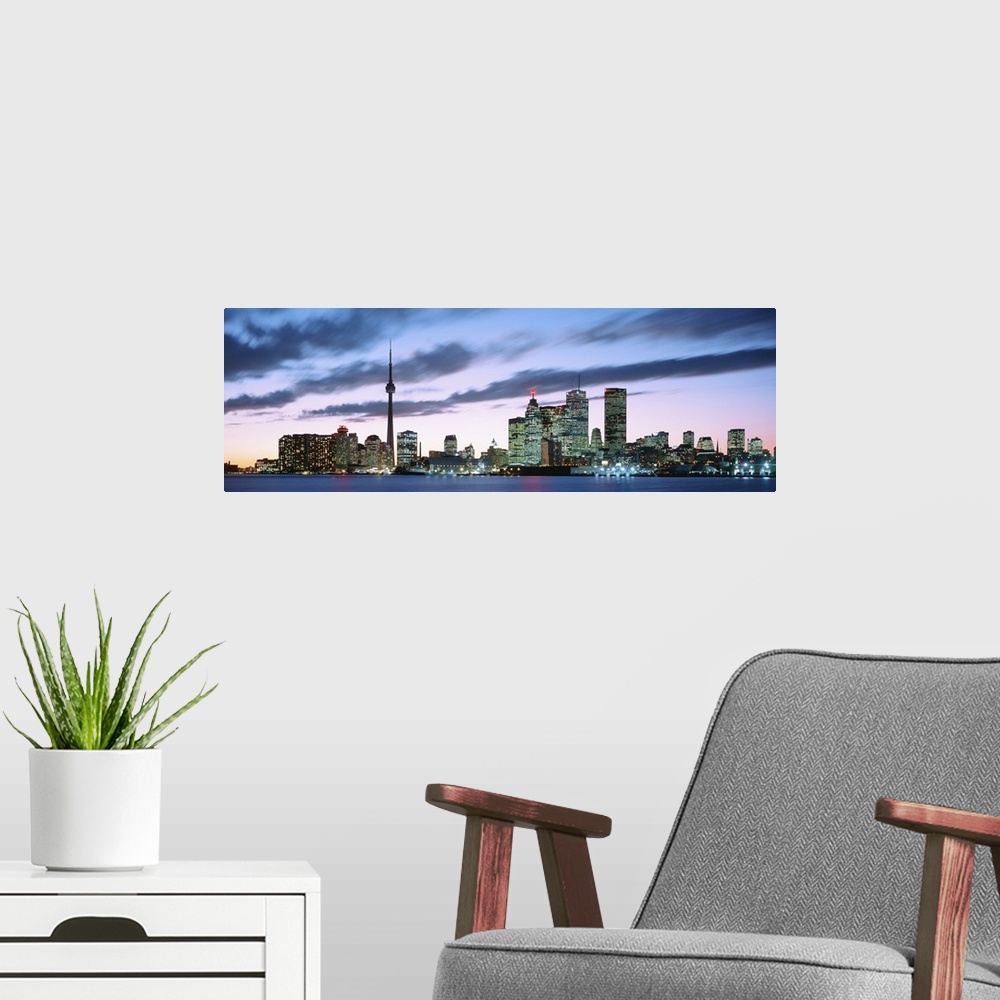 A modern room featuring Panoramic photograph of the modern city of Toronto at twilight, under dark clouds in a pastel sky...