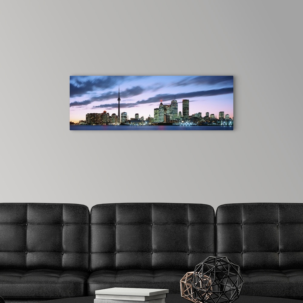 A modern room featuring Panoramic photograph of the modern city of Toronto at twilight, under dark clouds in a pastel sky...