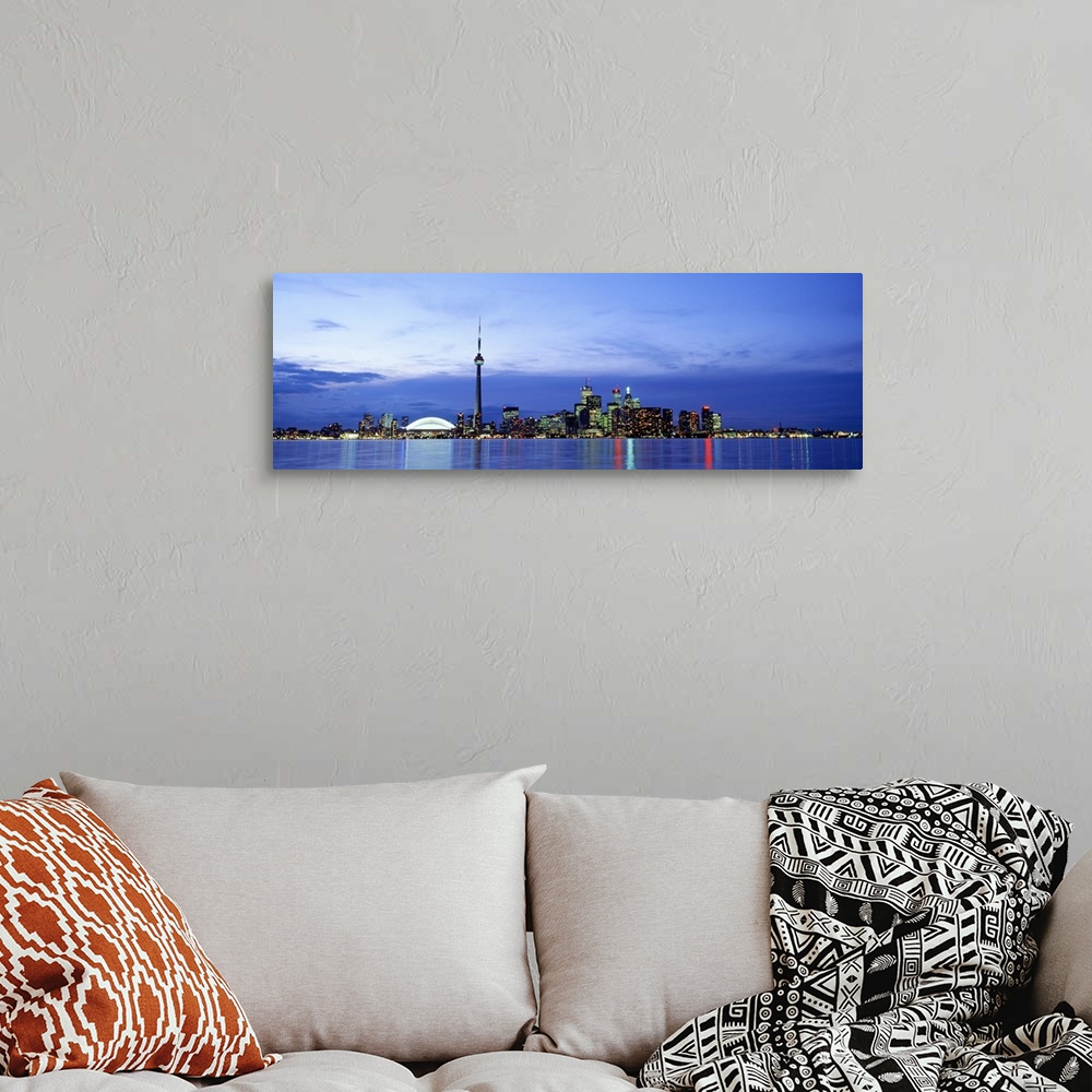 A bohemian room featuring A wide angle photograph taken of an illuminated skyline in Canada at dusk. The lights reflect in ...