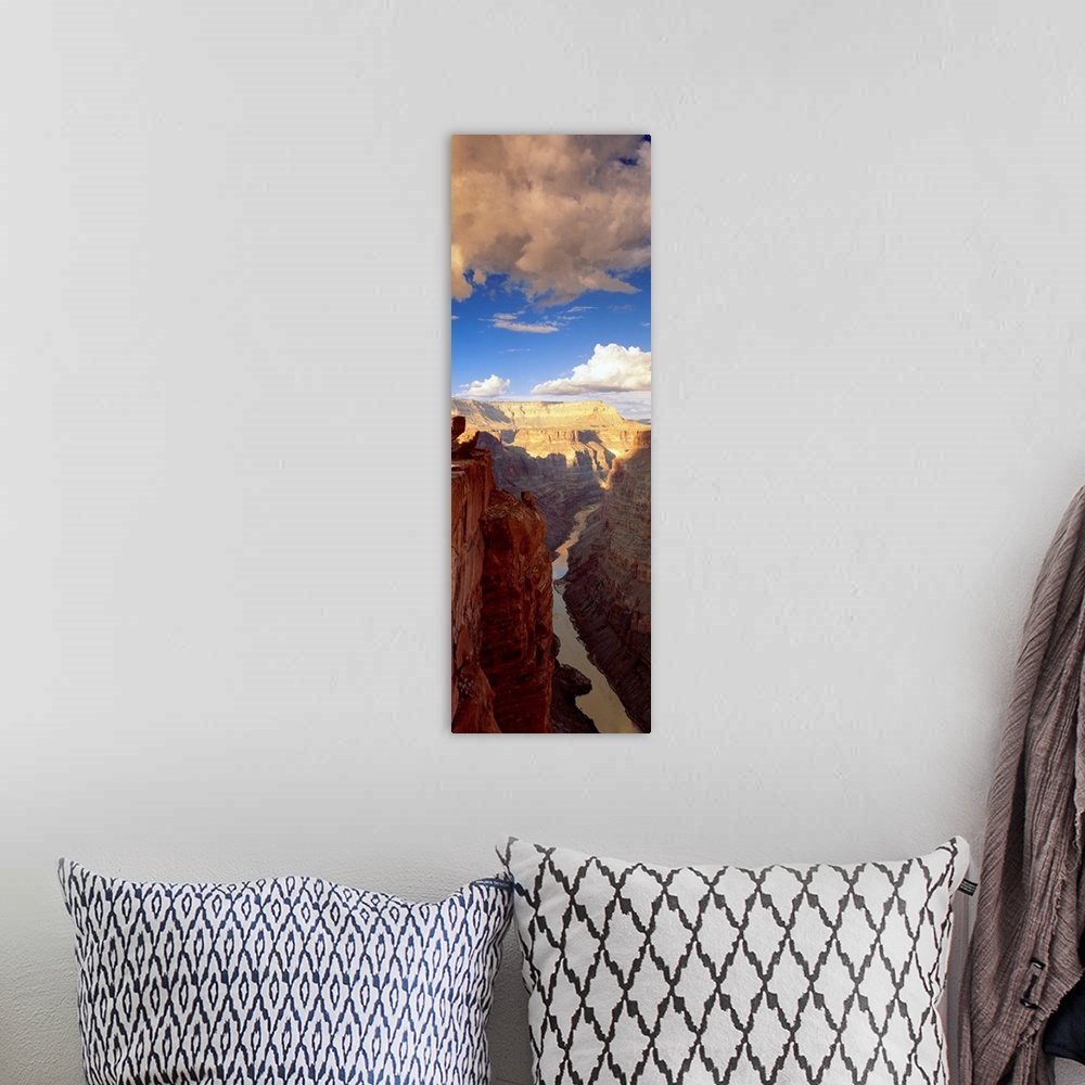 A bohemian room featuring Vertical panoramic photograph river running through tall rocky vertical gorge under a cloudy sky.