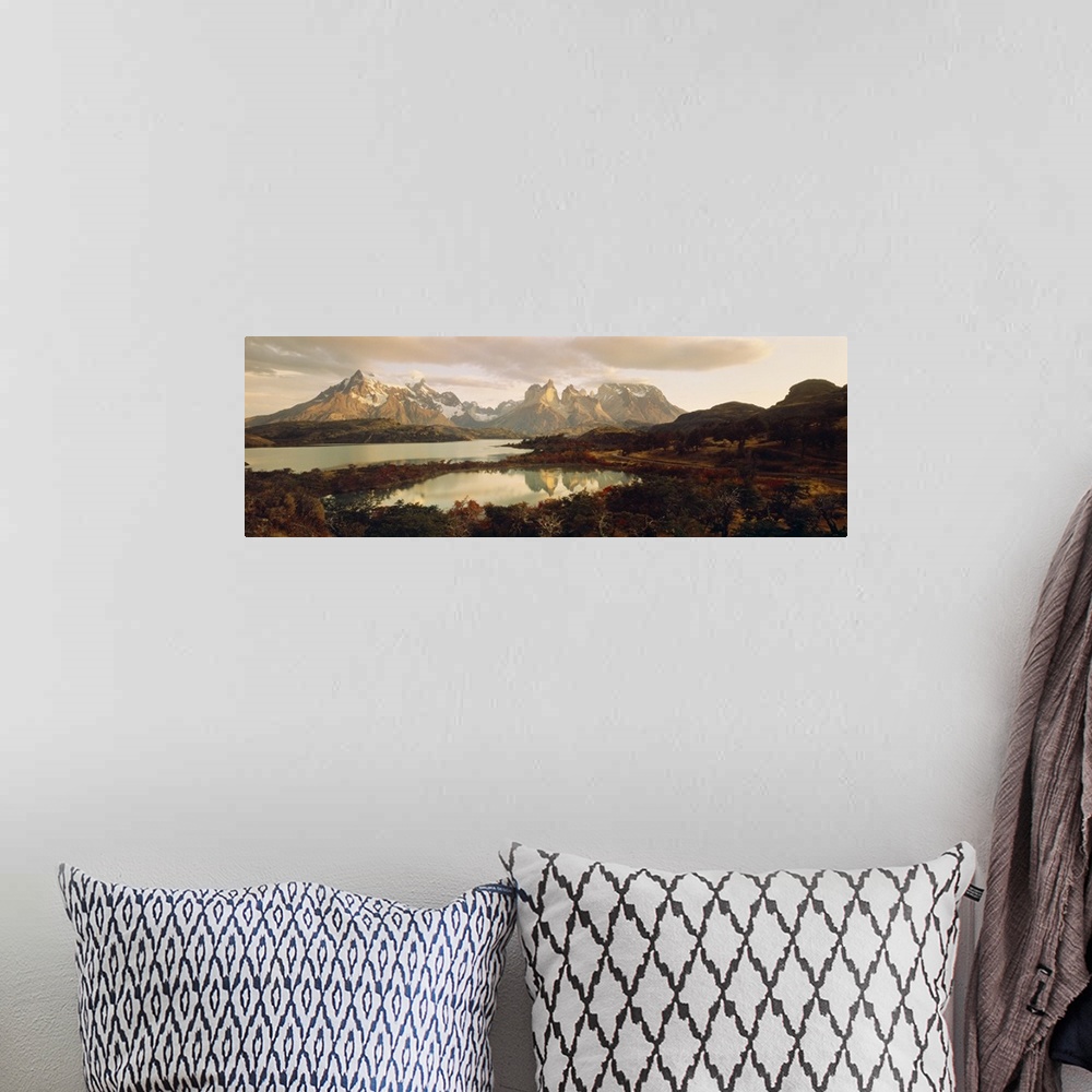 A bohemian room featuring Big, landscape, wide angle photograph of snow covered mountains behind waters surrounded by fores...