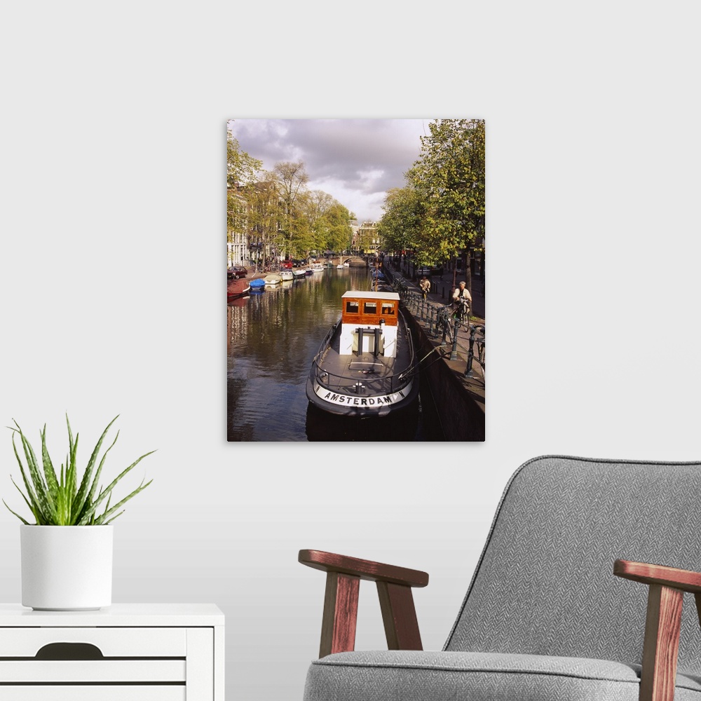 A modern room featuring Tourboat docked in a channel, Amsterdam, Netherlands