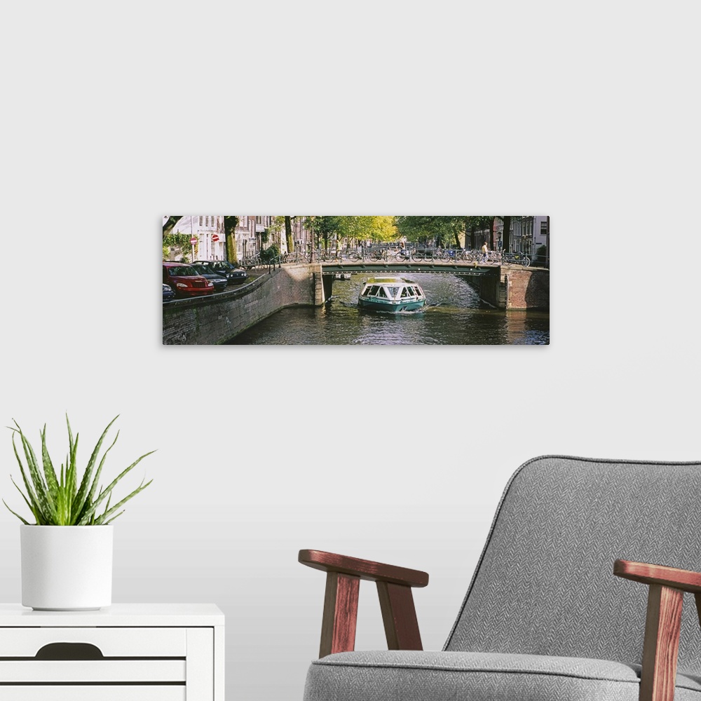 A modern room featuring Tourboat under a bridge in a channel, Amsterdam, Netherlands