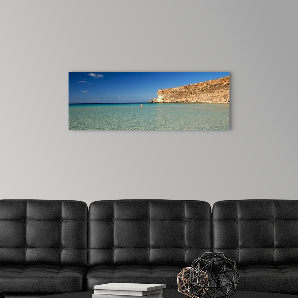 A modern room featuring Tourist walking in the sea, Spiaggia Dei Conigli, Italy