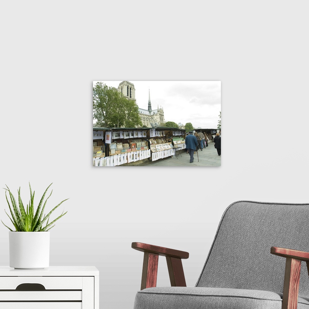 A modern room featuring Tourists at the market stall with cathedral in the background, Notre Dame De Paris, Paris, Ile de...