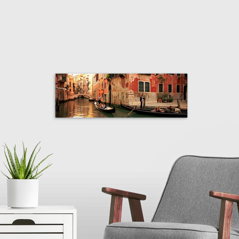 A modern room featuring Gondolas paddling through canals lined with historic Venetian buildings.