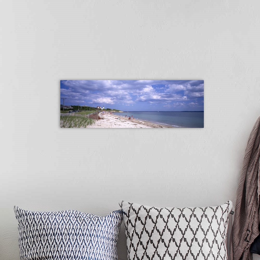 A bohemian room featuring A wide angle photograph is taken of a beach in Cape Cod that only has a few people on it. A light...