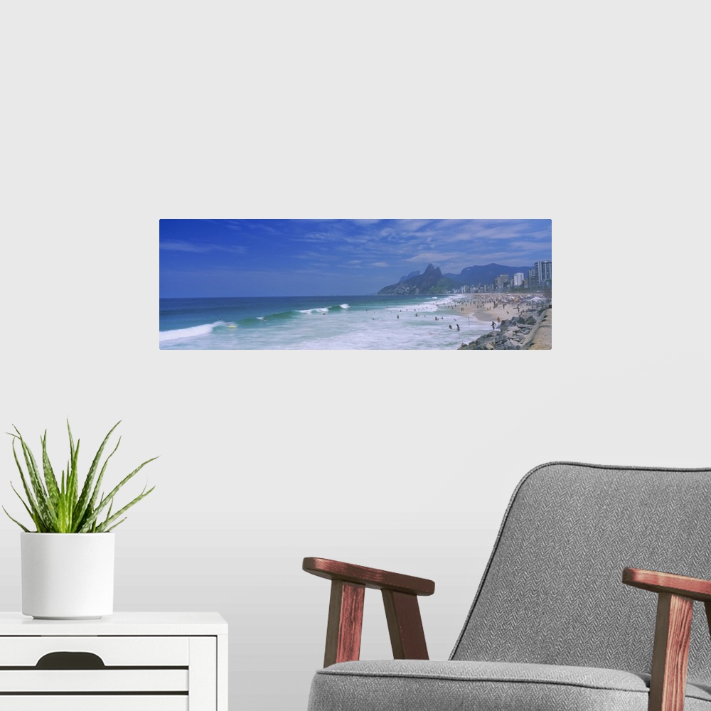 A modern room featuring Panoramic photo on canvas of a crowded beach in Brazil with waves crashing ashore.