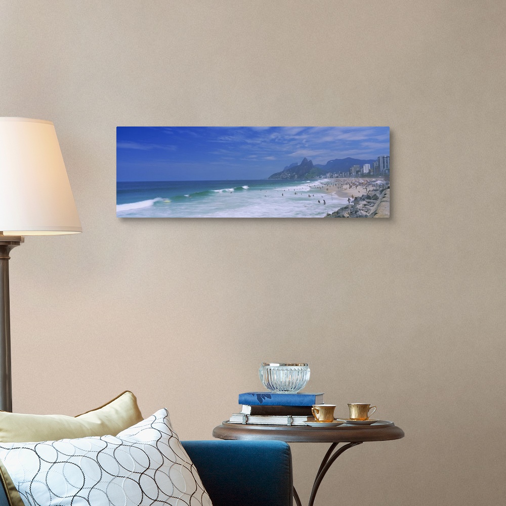 A traditional room featuring Panoramic photo on canvas of a crowded beach in Brazil with waves crashing ashore.