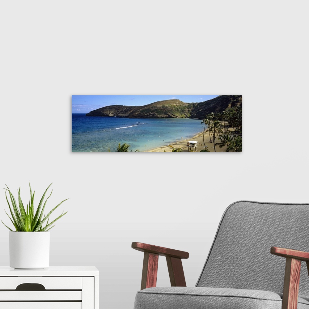 A modern room featuring Wide angle photograph taken on a beach in Hawaii that is surrounded by mountainous terrain and sh...