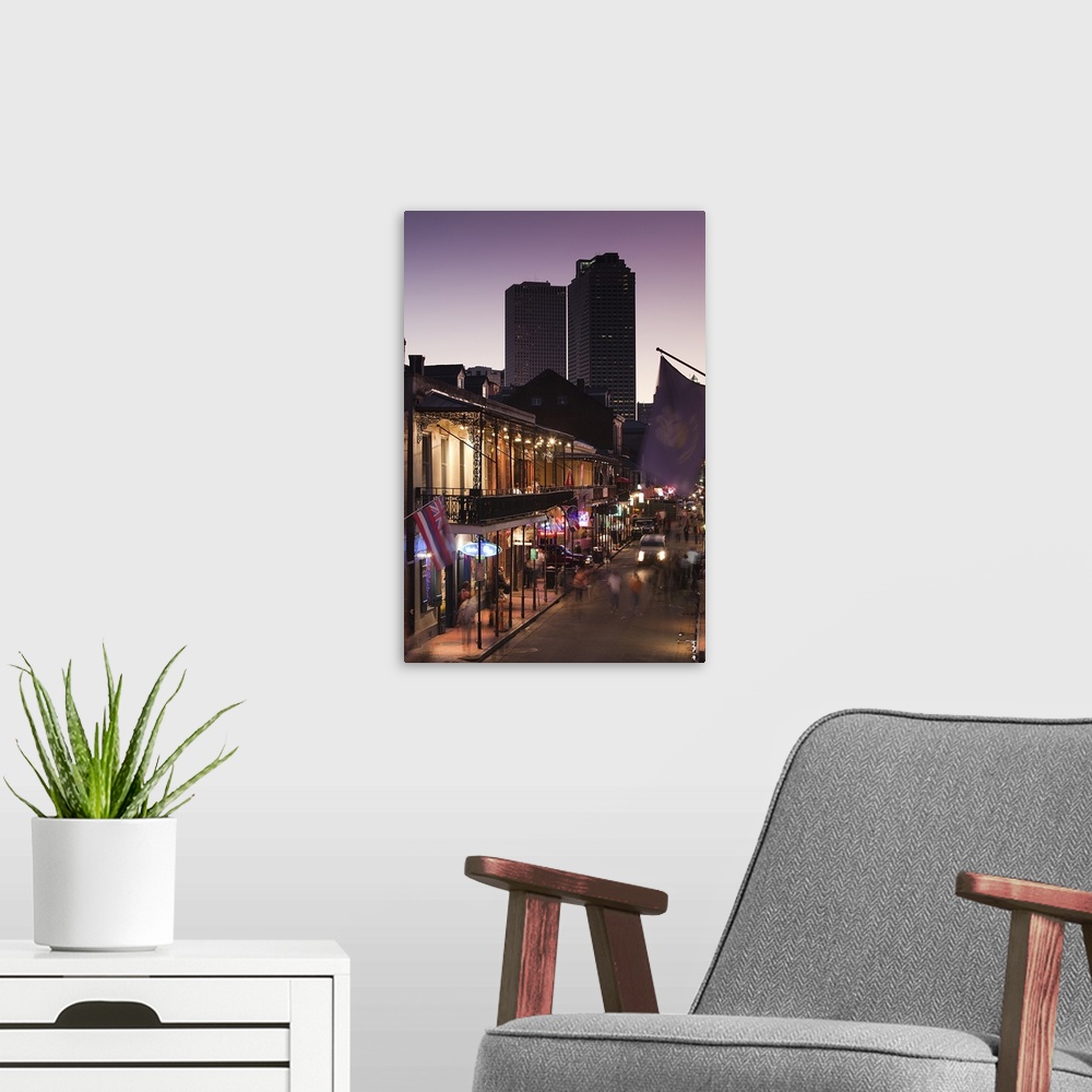 A modern room featuring People stroll down Bourbon Street in the French Quarter in New Orleans, Louisianna (LA) at dusk w...