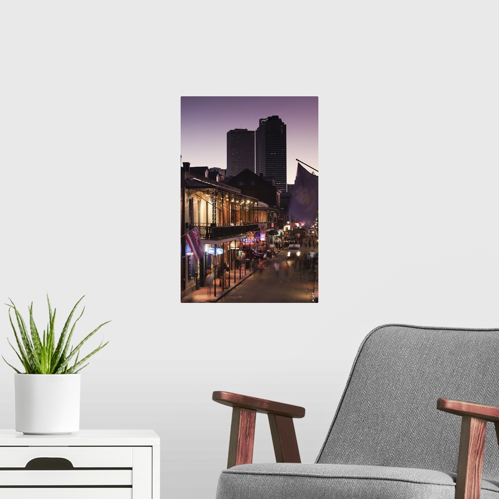 A modern room featuring People stroll down Bourbon Street in the French Quarter in New Orleans, Louisianna (LA) at dusk w...
