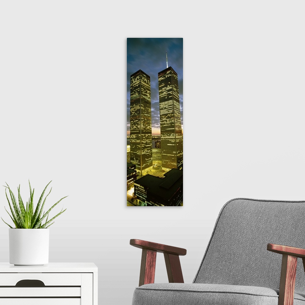 A modern room featuring Panoramic photograph focuses on the nicknamed ""Twin Towers"" lit up at nighttime.  At the base o...