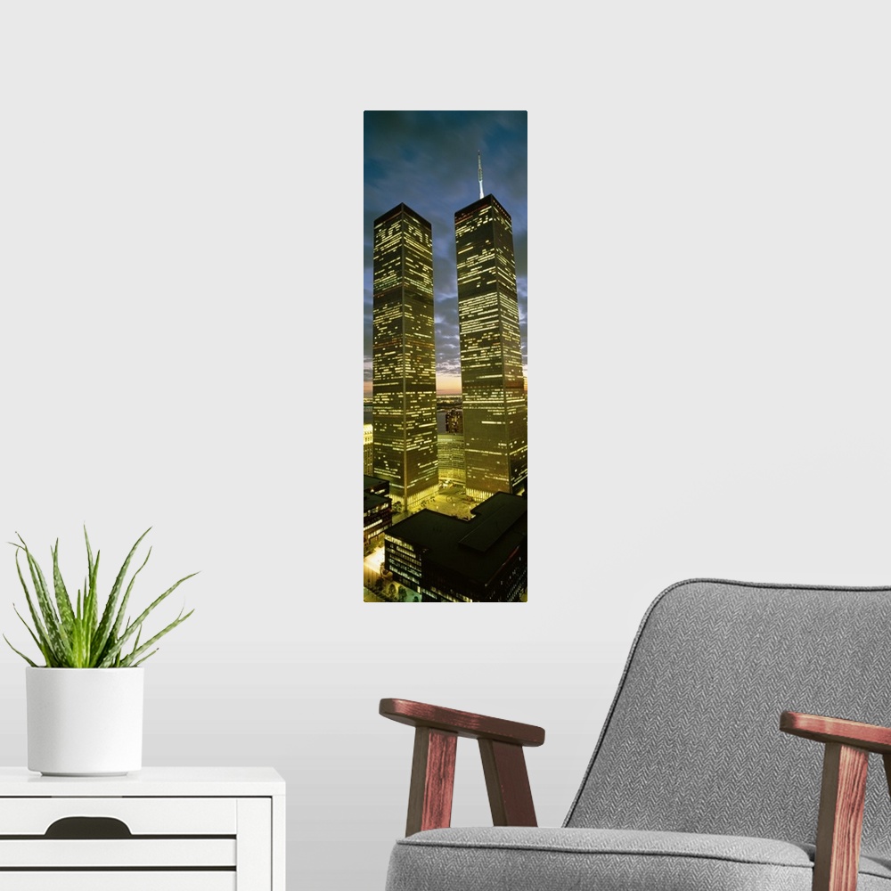 A modern room featuring Panoramic photograph focuses on the nicknamed ""Twin Towers"" lit up at nighttime.  At the base o...