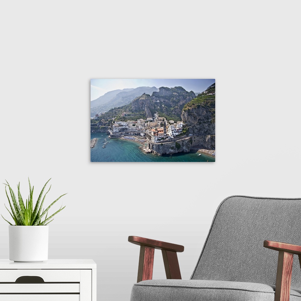 A modern room featuring Big canvas photo of a small town on cliffs and mountains that over look the ocean.