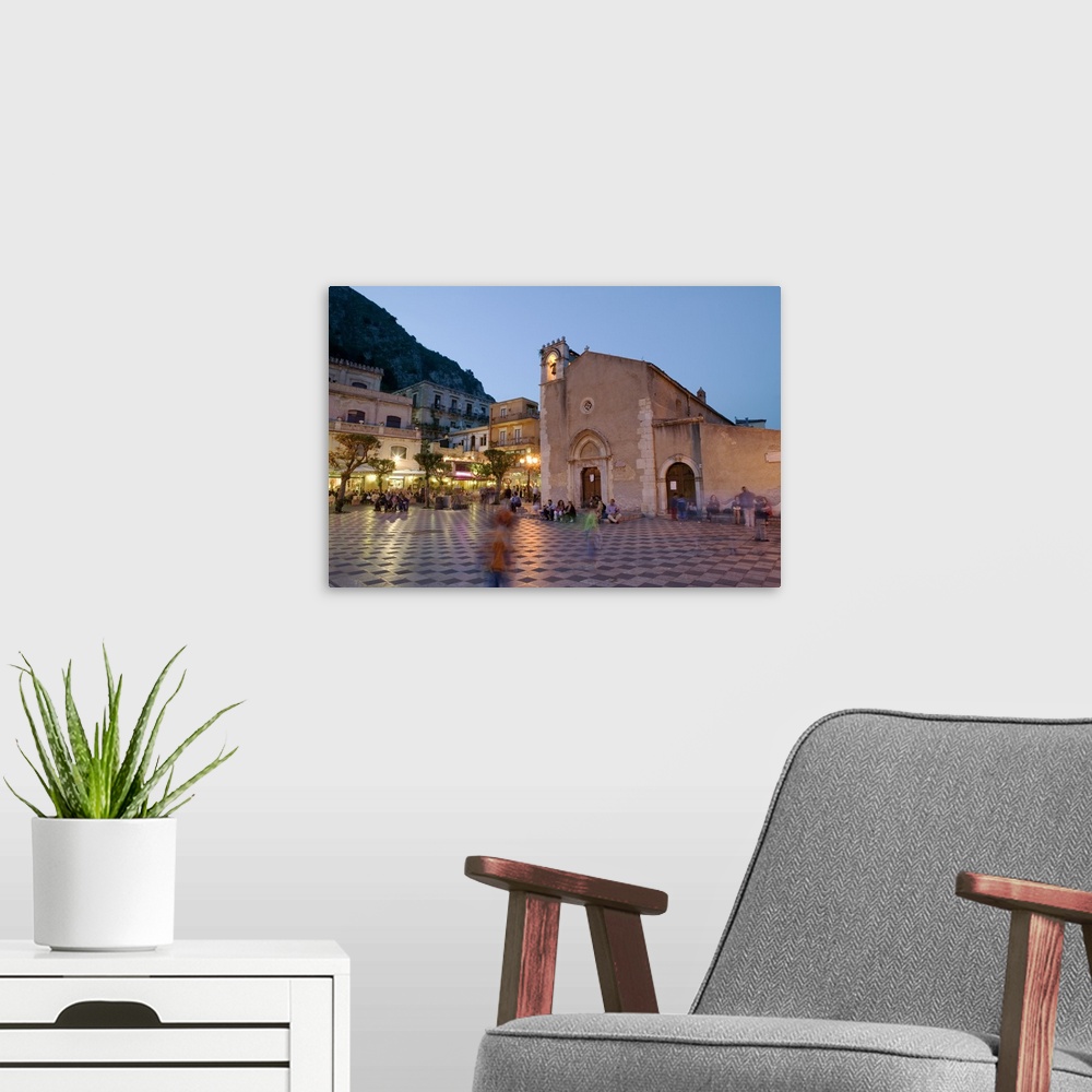 A modern room featuring Town square lit up at dusk, Piazza IX Aprile, Taormina, Sicily, Italy