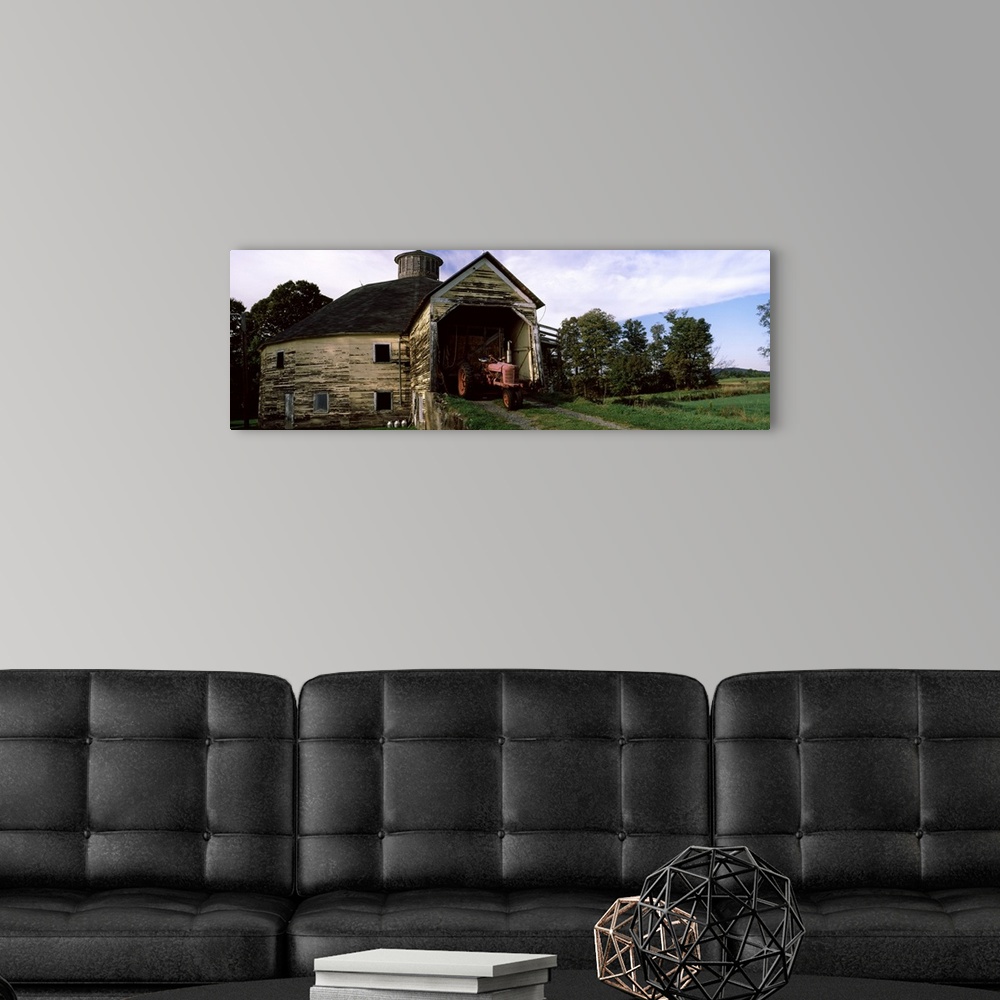 A modern room featuring Tractor parked inside of a round barn, Vermont,