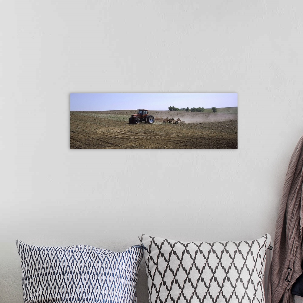 A bohemian room featuring Tractor ploughing field, Kansas