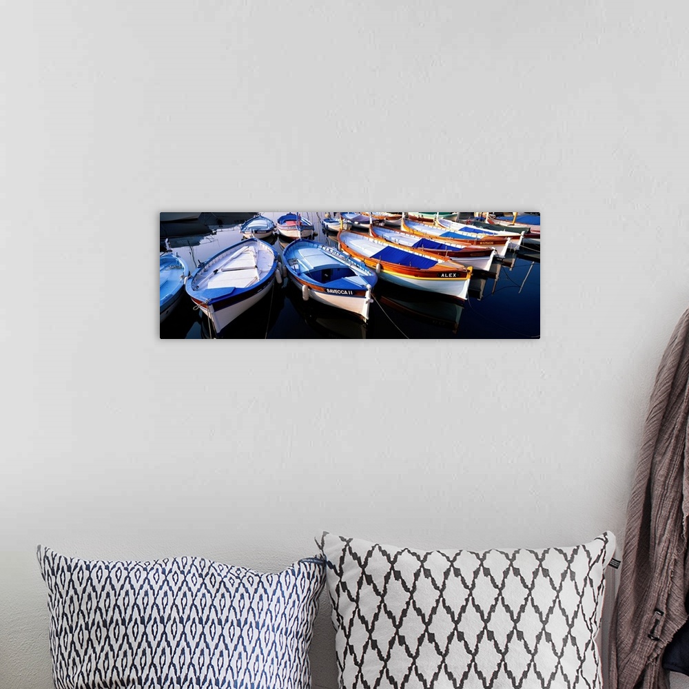 A bohemian room featuring Panoramic photograph of colorful boats strung up in rows.