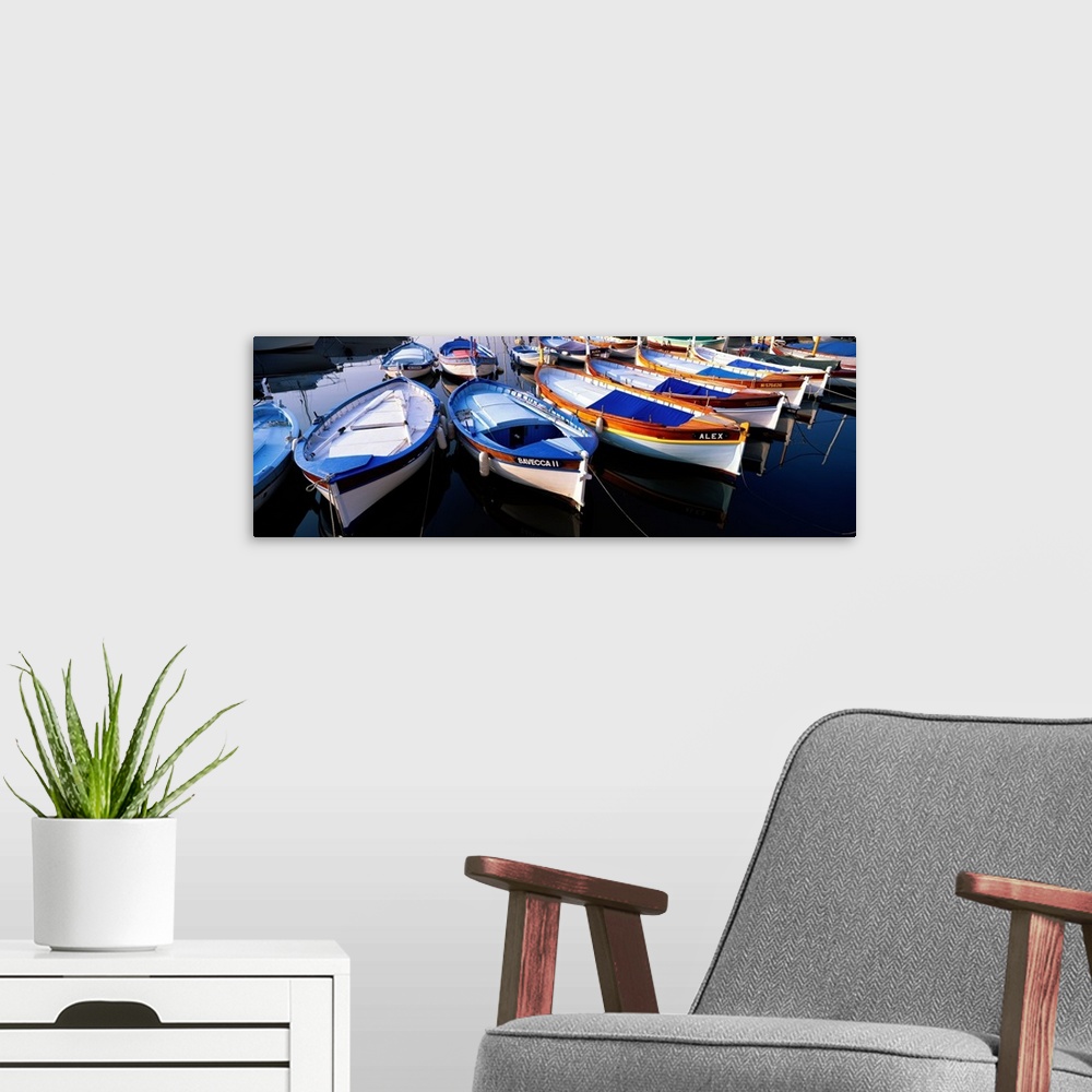 A modern room featuring Panoramic photograph of colorful boats strung up in rows.