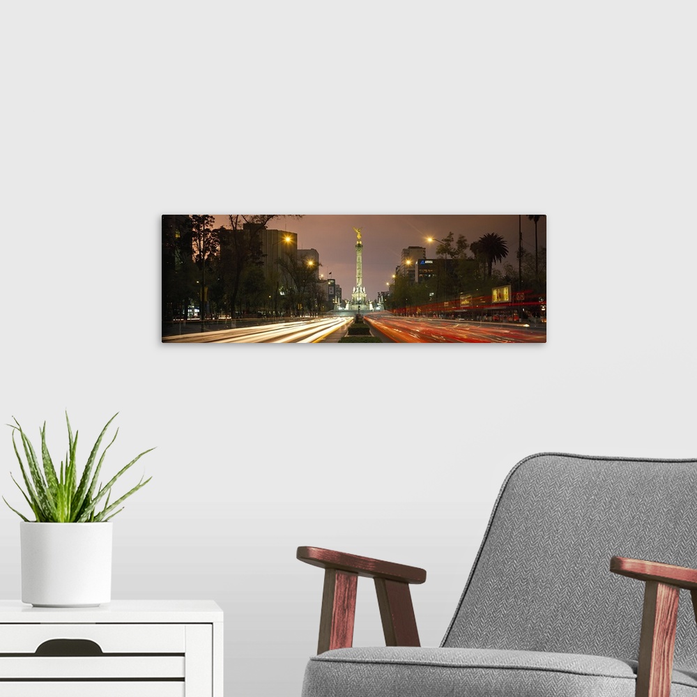 A modern room featuring Traffic on road with victory column at night, Independence Monument, Paseso Del La Reforma, Mexic...