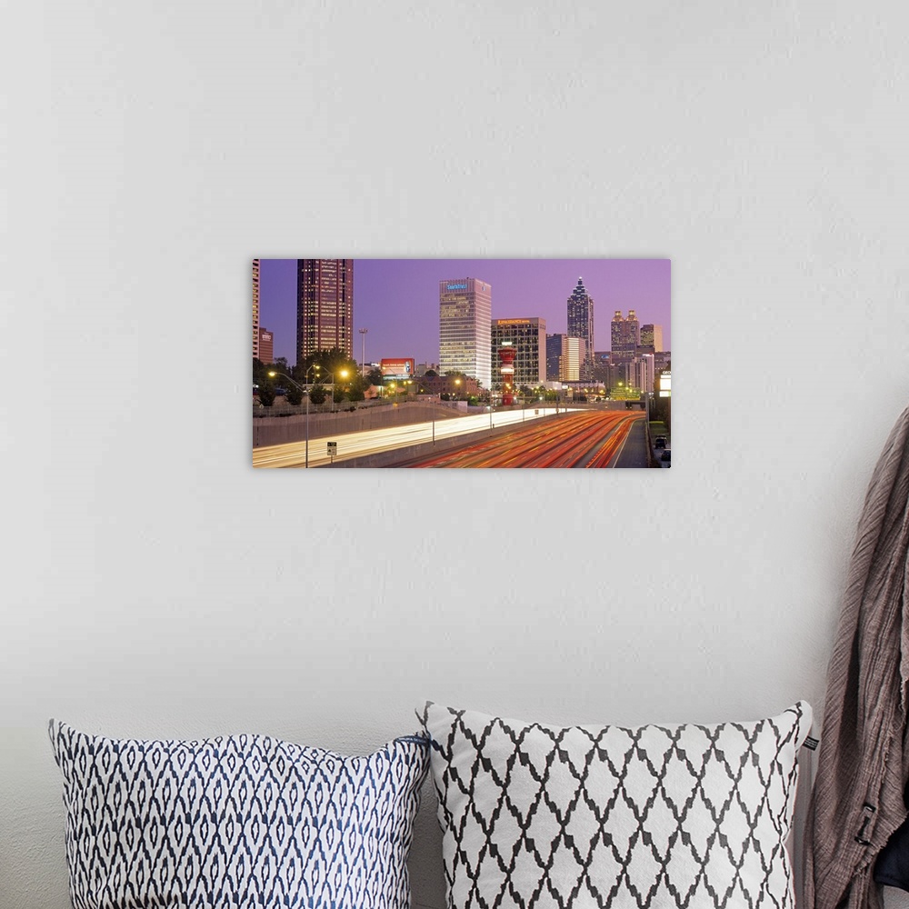 A bohemian room featuring Panoramic photograph of highway filled with light trails lined by lit up buildings at sunset.