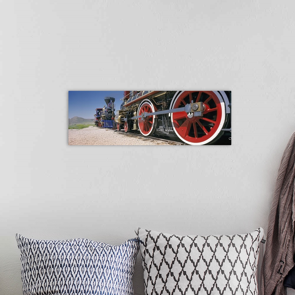 A bohemian room featuring Panoramic photograph taken of the bottom of vintage trains as they ride on the tracks.