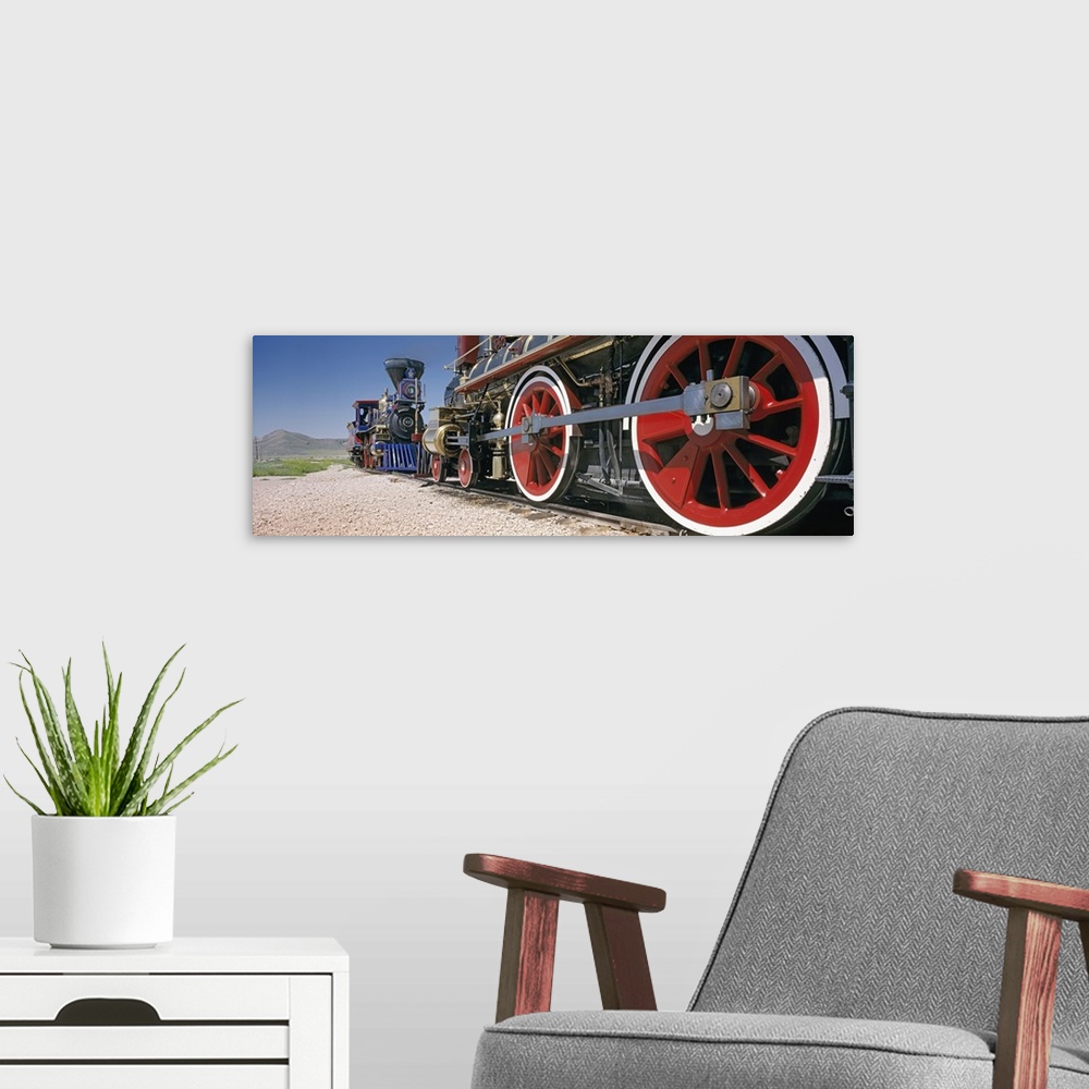 A modern room featuring Panoramic photograph taken of the bottom of vintage trains as they ride on the tracks.