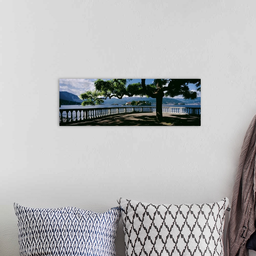 A bohemian room featuring Panoramic photo on canvas of a tree branching out over a view of a lake with rolling mountains in...