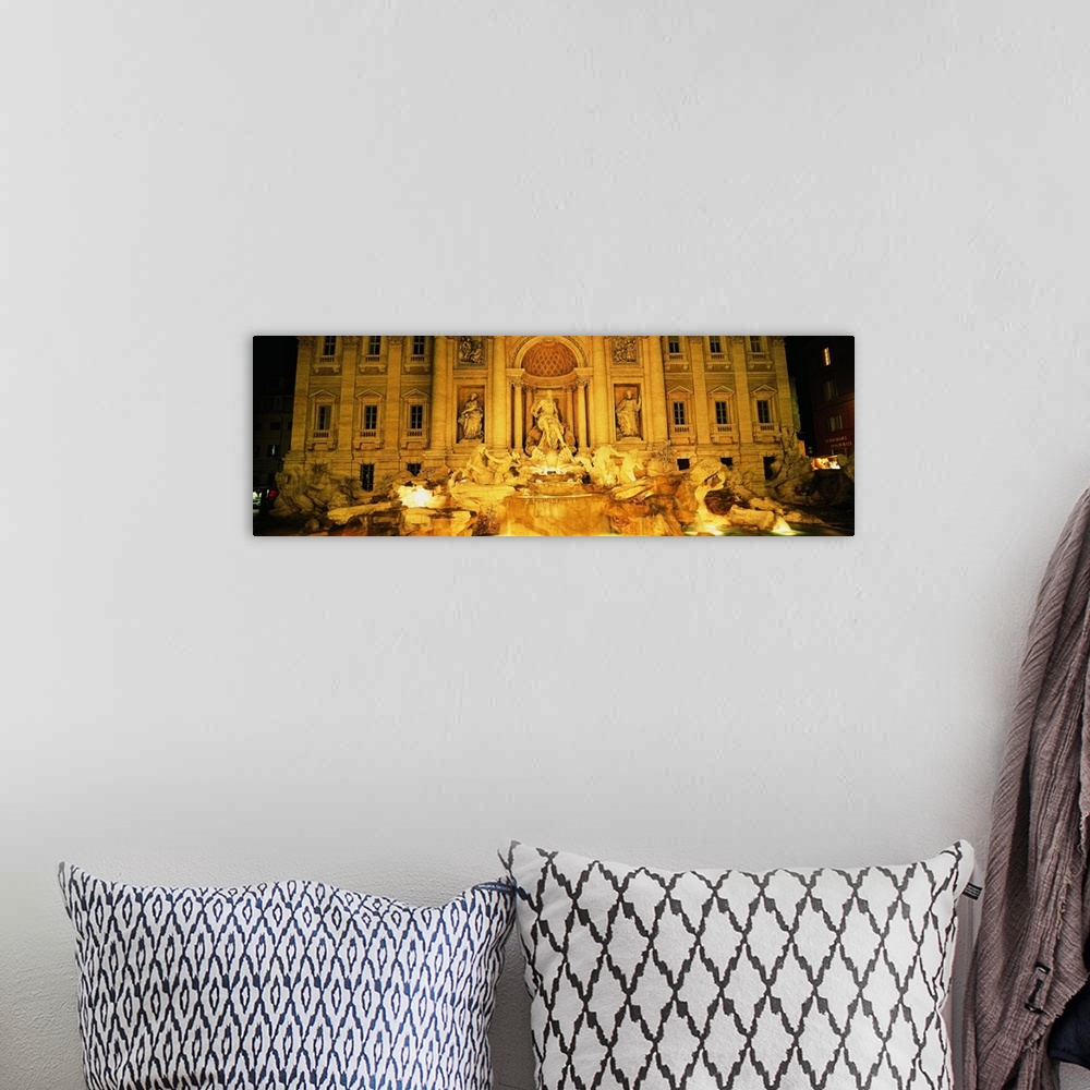 A bohemian room featuring Panoramic photograph taken of the Trevi fountain illuminated at night.