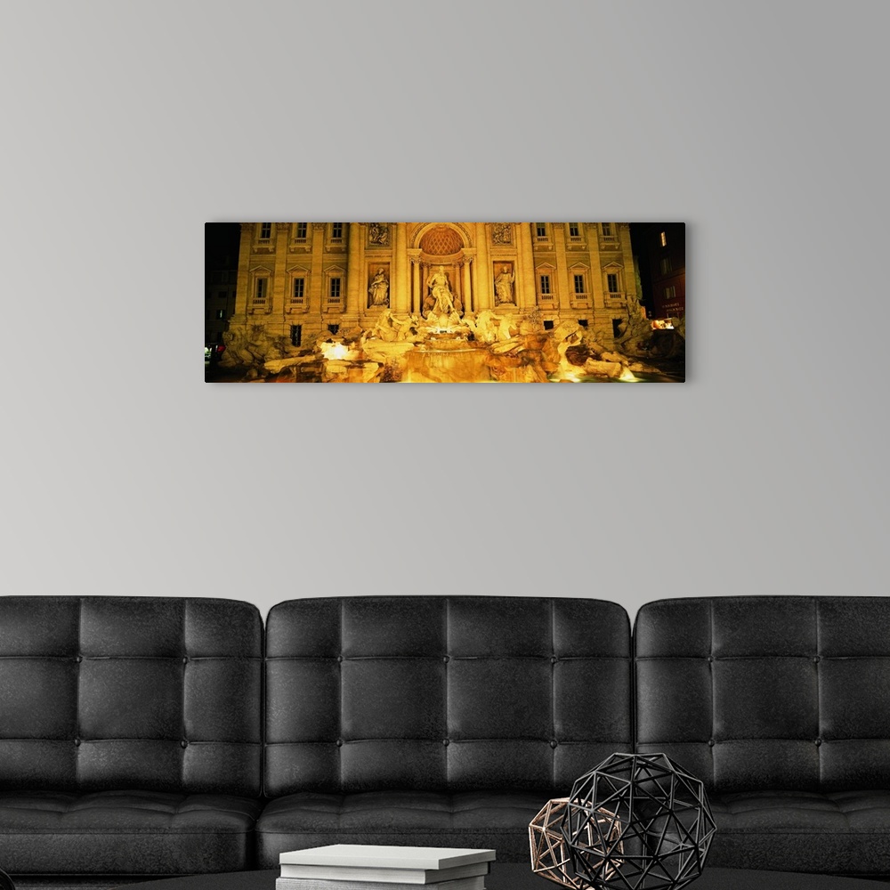A modern room featuring Panoramic photograph taken of the Trevi fountain illuminated at night.