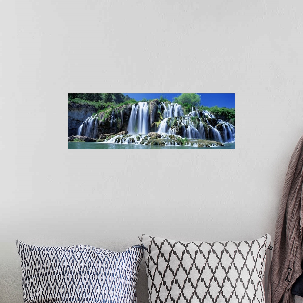 A bohemian room featuring Wide angle photograph of Tributary Waterfall, beneath a blue sky, pouring into the Snake River in...