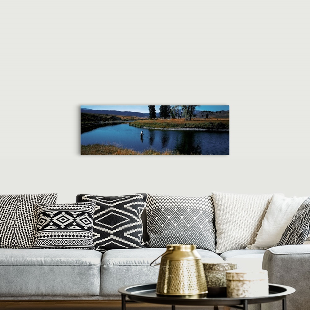 A bohemian room featuring Giant, landscape photograph of Slough Creek in Yellowstone National Park in Wyoming, surrounded b...