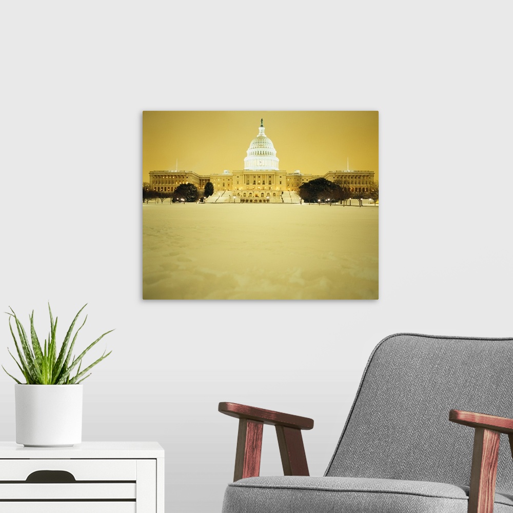 A modern room featuring US Capitol Building illuminated at night with snow, Washington DC