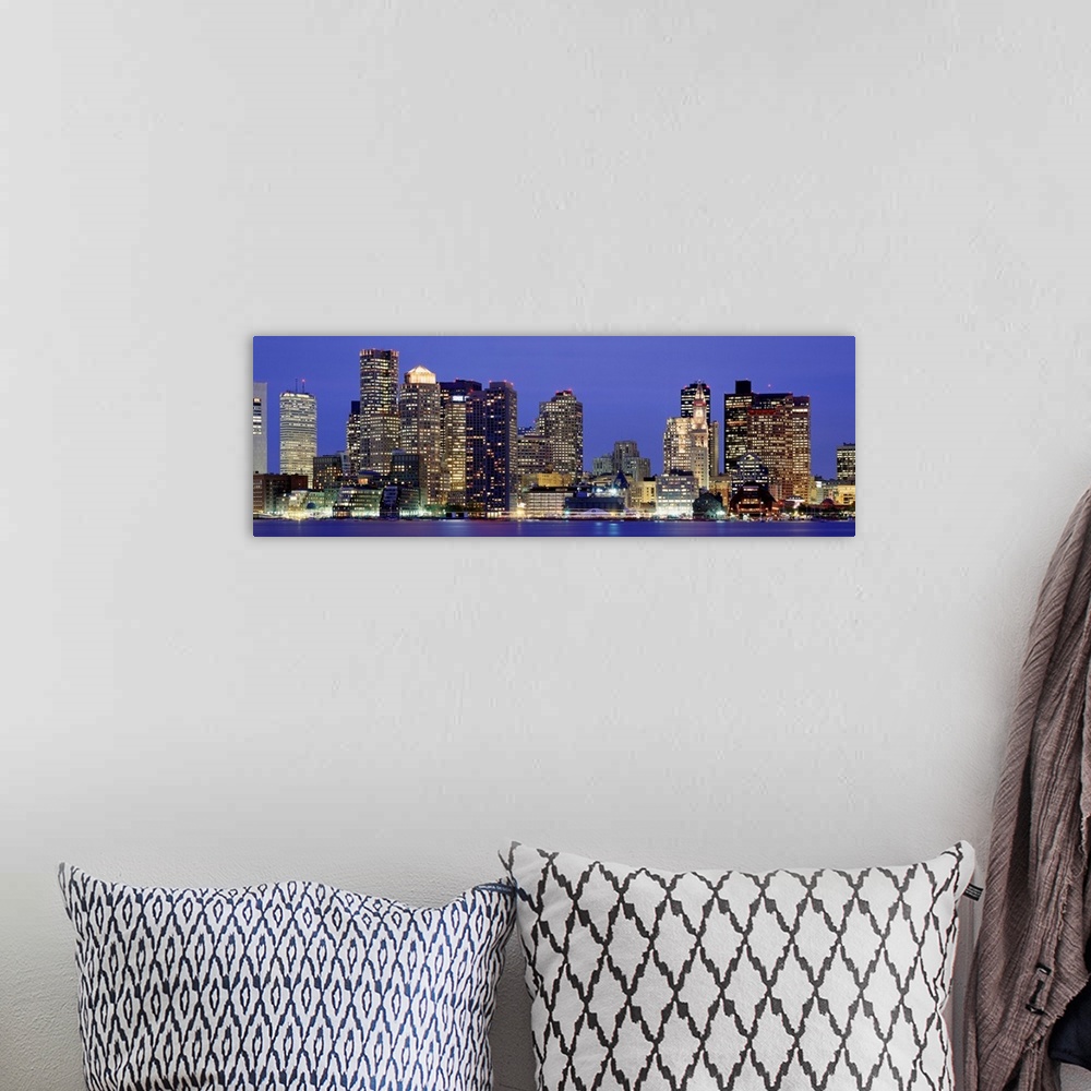 A bohemian room featuring A panoramic photograph taken from the water of sky scrapers in the dark.