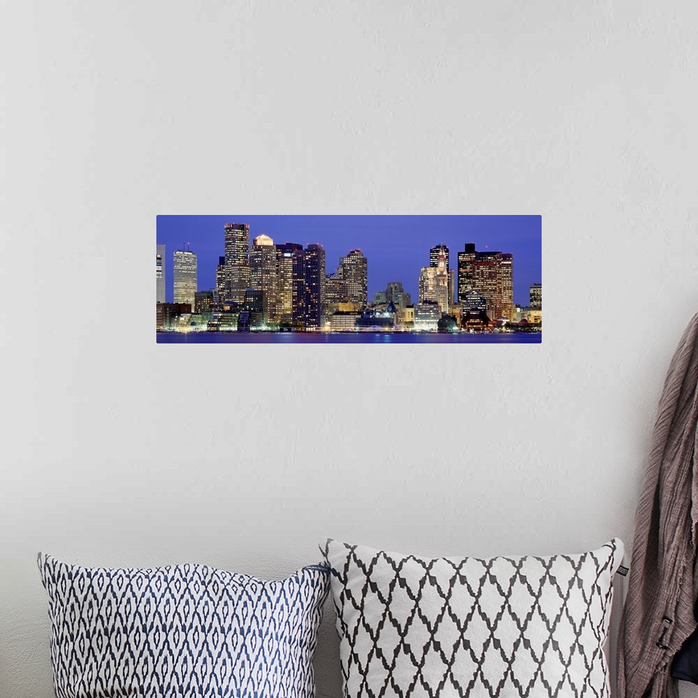 A bohemian room featuring A panoramic photograph taken from the water of sky scrapers in the dark.