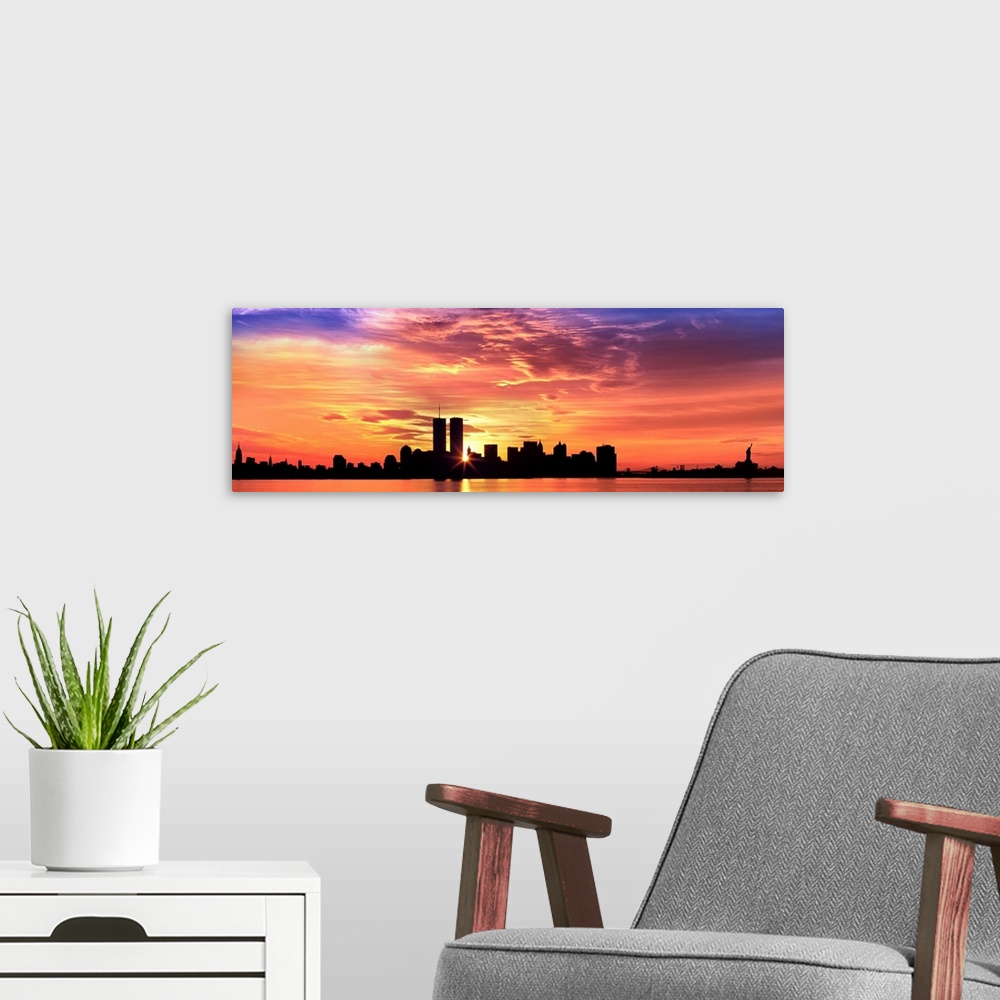 A modern room featuring Panoramic photograph of the NY City skyline with the sun peering through the buildings with the H...