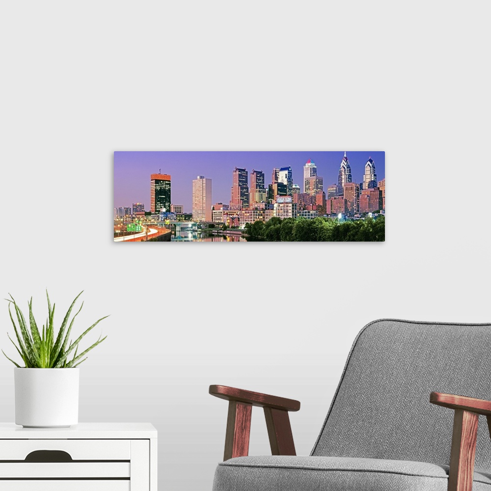 A modern room featuring Panoramic photograph taken at nighttime in the largest city within Pennsylvania shows a group of ...