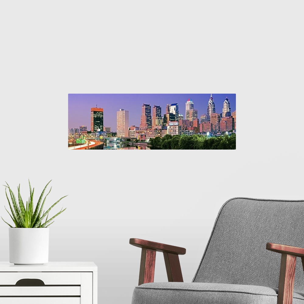 A modern room featuring Panoramic photograph taken at nighttime in the largest city within Pennsylvania shows a group of ...